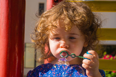 Close-up portrait of cute girl holding camera