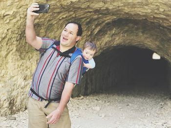 Happy father taking selfie with son in tunnel