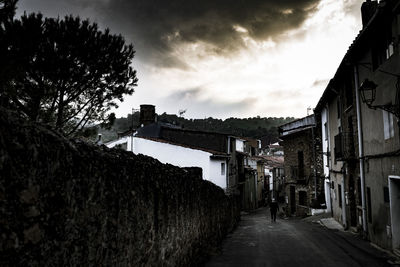 Alley amidst buildings in city against sky