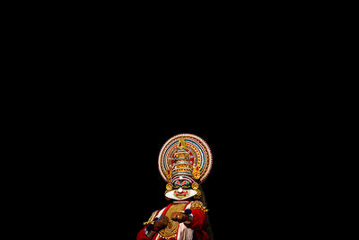 Low angle view of illuminated lighting equipment against black background