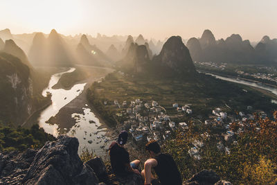 People looking at view of mountains against sky