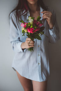 Midsection of woman holding bouquet