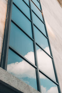 Low angle view of modern glass building against sky