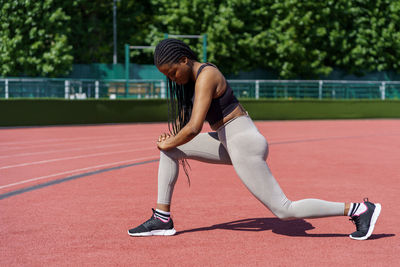African american lady with long braids enjoys effective exercise for gluteal muscles on city stadium