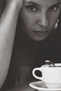 Close-up portrait of a young woman drinking coffee