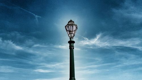 Low angle view of illuminated street light against blue sky