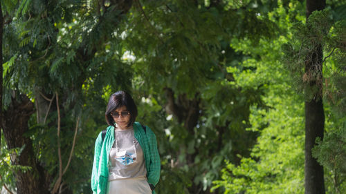 Portrait of young woman standing in forest