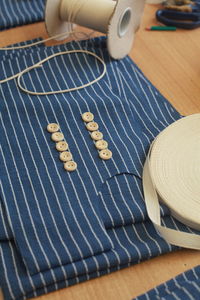 High angle view of blue cloth with sewing items on table