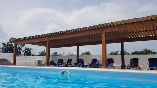 People swimming in pool against sky