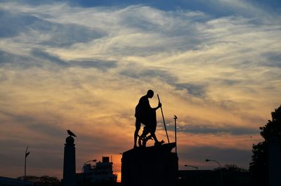 Low angle view of built structure against sky at sunset