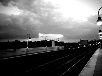 Railroad tracks against cloudy sky