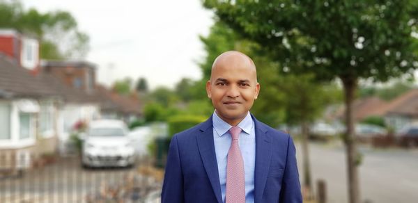 Portrait of bald well-dressed man standing in city