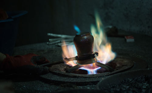 Close-up of hand holding container on fire