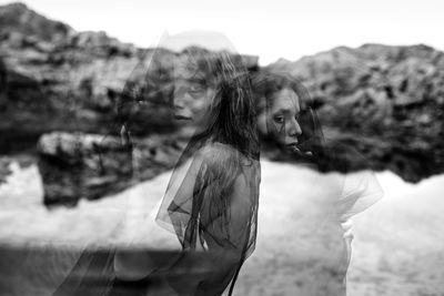 Young woman standing against sky