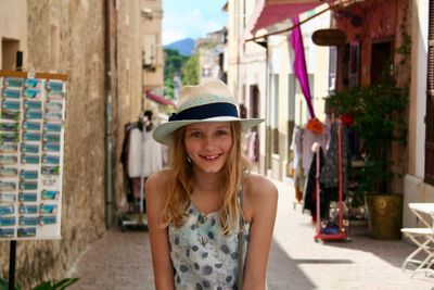 Portrait of smiling girl wearing hat in town