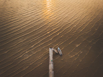 High angle view of fishing boat moored at sea during sunset