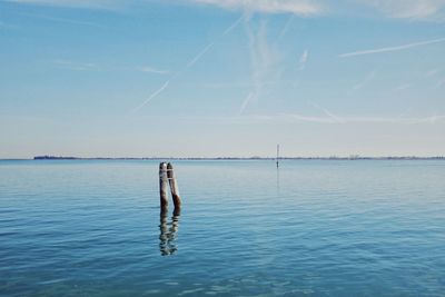 Man in blue sea against sky