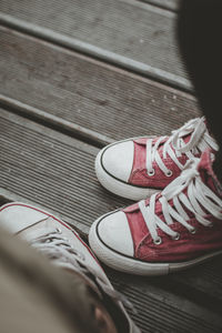 Low section of people wearing shoes standing on footpath