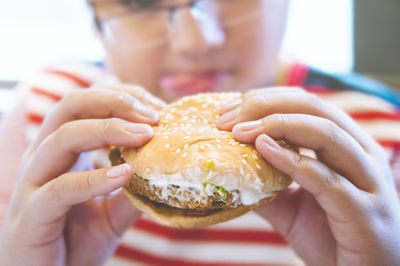 Close-up of teenage boy eating burger