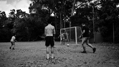 Rear view of men playing on the ground