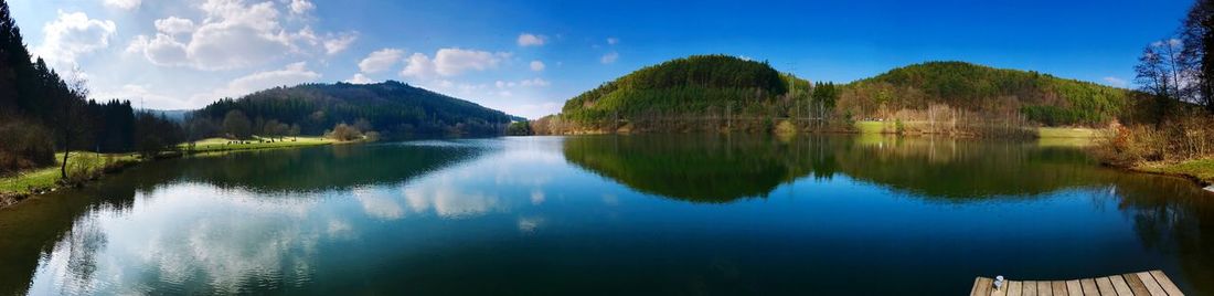 Panoramic view of lake and mountains against blue sky