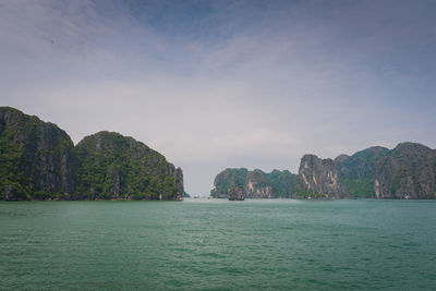 Scenic view of sea and mountains against sky