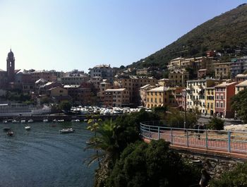 Aerial view of townscape by river against clear sky