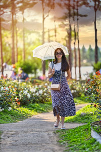 Full length of woman with umbrella standing in rain