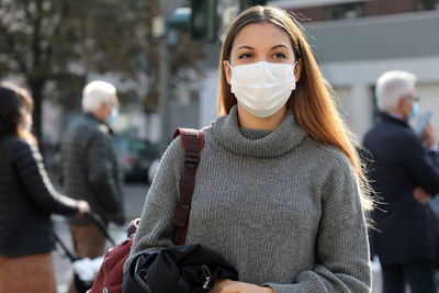 Beautiful woman wearing mask standing outdoors