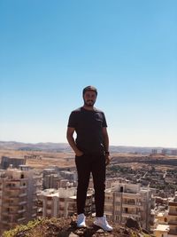 Portrait of man standing against cityscape