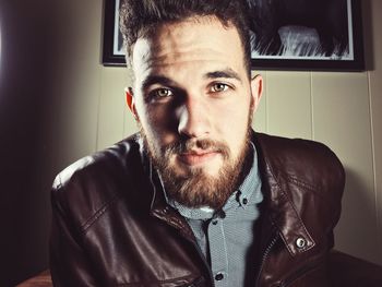 Portrait of young man wearing jacket sitting at home