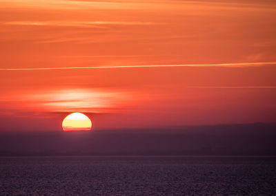 Scenic view of sea against romantic sky at sunset