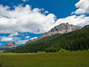 Scenic view of green landscape and mountains against sky