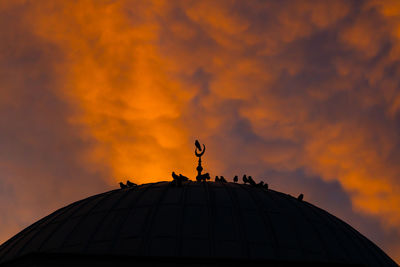 Low angle view of cross against sky during sunset