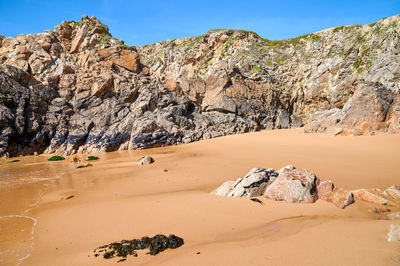 Small rocky cove with a beach and seashell-covered rocks