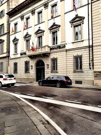 Cars on road by buildings in city
