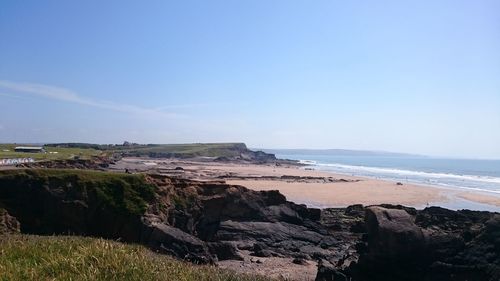 Scenic view of beach against clear blue sky