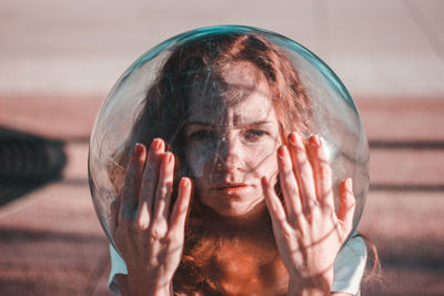 Close-up of portrait young woman wearing glass helmet in head during sunny day