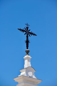 Low angle view of cross against blue sky