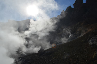 Numerous fumaroles with hot geothermal steam rusing up from the volcanic surface.