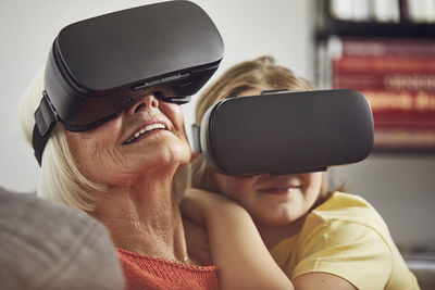 Grandmother using vr glasses with her grandson