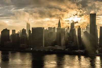 Skyscrapers in city against cloudy sky