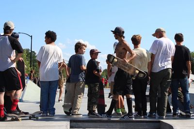 People standing at music concert against sky