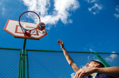 Low angle view of man playing basketball sky