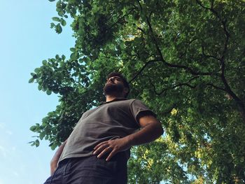 Low angle view of man standing against trees