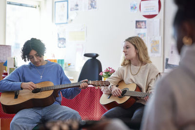 Teenagers attending guitar lesson