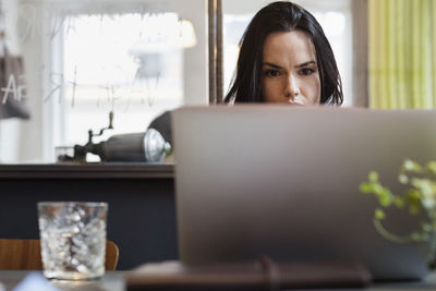 Concentrated blogger using laptop at table in creative office