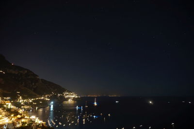 Illuminated city against sky at night