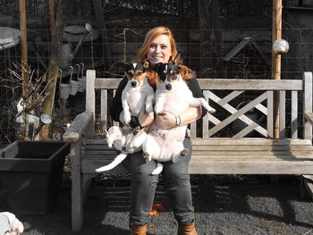 Happy woman playing with dogs at backyard