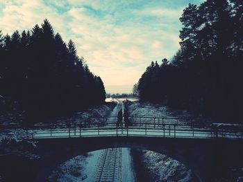 Footbridge over river against sky